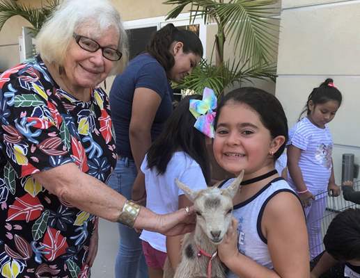 silverado resident with goat and young girl