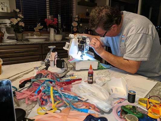 man sewing face masks